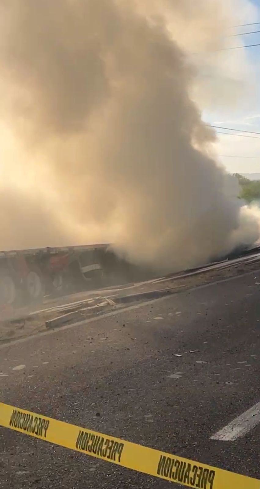 Fuerte incendio en tráiler volcado